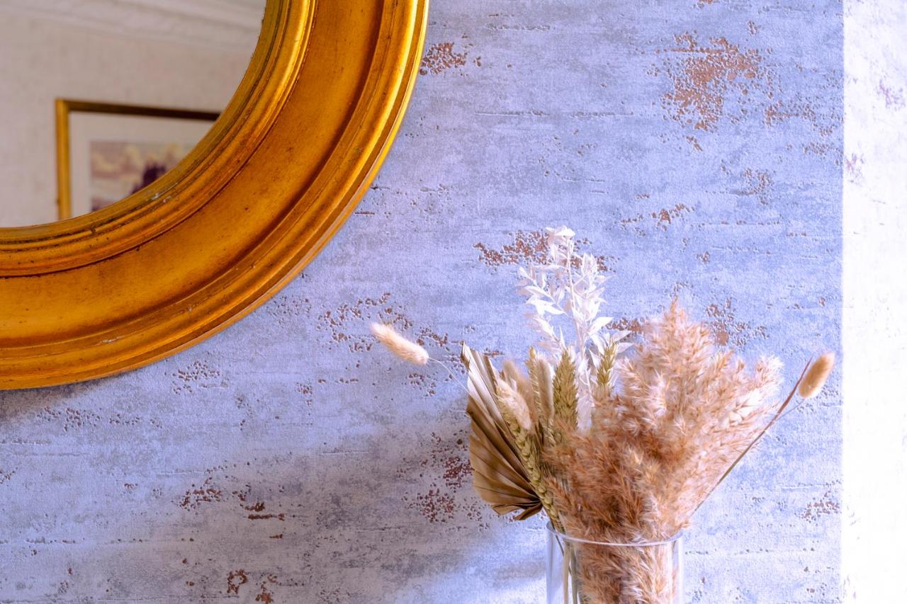 a vase with a plant in front of a mirror at Royal Hotel in Bath