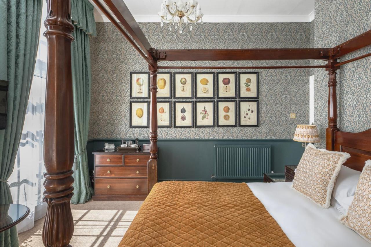 a bedroom with a canopy bed and a dresser at Royal Hotel in Bath
