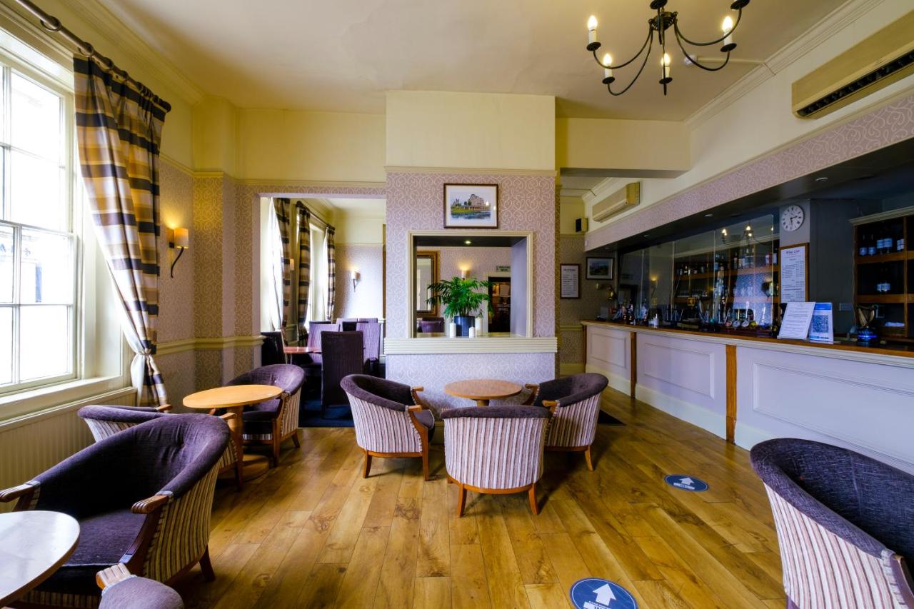 a restaurant with tables and chairs and a bar at Royal Hotel in Bath