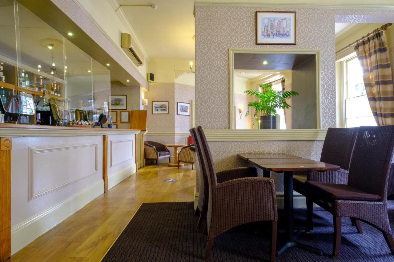 a restaurant with a table and chairs and a mirror at Royal Hotel in Bath